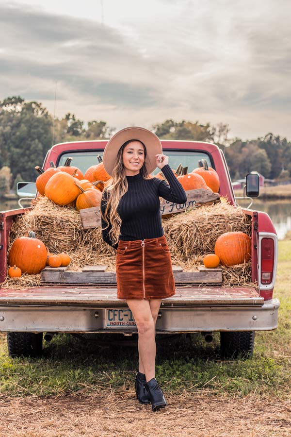 Sam in front of decorative pumpkin truck.